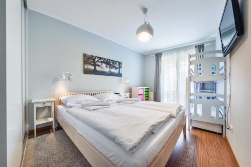 sypialnia z dużym łóżkiem i telewizorem w obiekcie Apartamenty Sun & Snow Polanki z sauną w Kołobrzegu