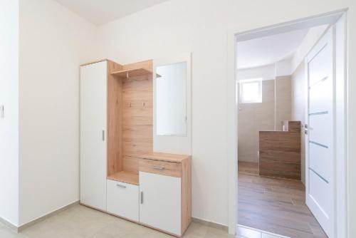 a dressing room with a mirror and a closet at Apartmány Noviny in Trenčín