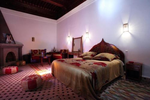 a bedroom with a large bed and a fireplace at Riad Tahar Oasis in Marrakesh