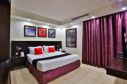 a bedroom with a large bed with red curtains at أحلى الأيام للوحدات الفندقية in Jeddah