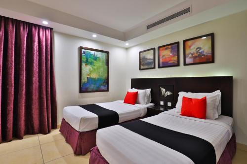a hotel room with two beds with red pillows at أحلى الأيام للوحدات الفندقية in Jeddah