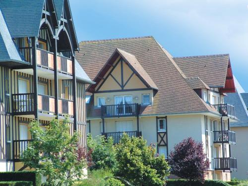 un gran edificio con balcones en un lateral en Lagrange Vacances Les Résidences en Cabourg