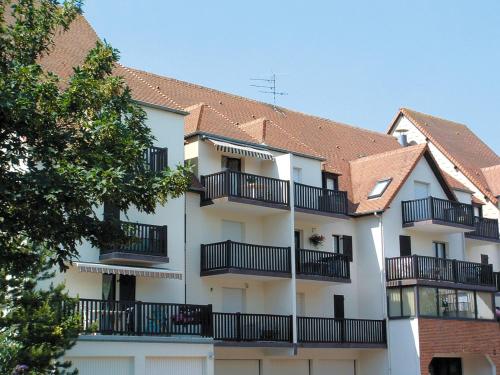 un edificio blanco con balcones negros. en Lagrange Vacances Les Résidences, en Cabourg