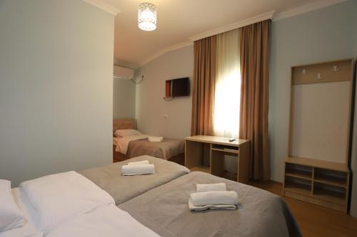 ein Hotelzimmer mit zwei weißen Handtüchern auf einem Bett in der Unterkunft Hotel Hollywood in Kutaissi