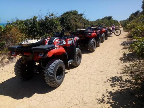 a row of atvs parked on a dirt road at Pousada Aconchego in Pitimbu