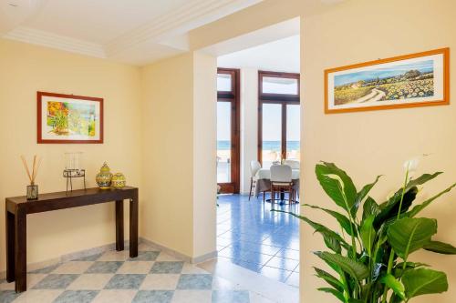 a living room with a table and a plant at Mira Spiaggia in San Vito lo Capo