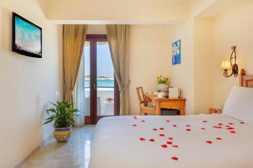 a bedroom with a bed with roses on the bedspread at Mira Spiaggia in San Vito lo Capo