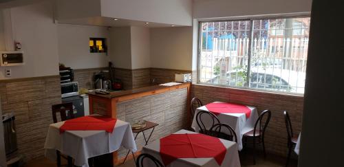 un restaurante con mesas y sillas rojas y blancas en Hostal del Centro Concepción, en Concepción