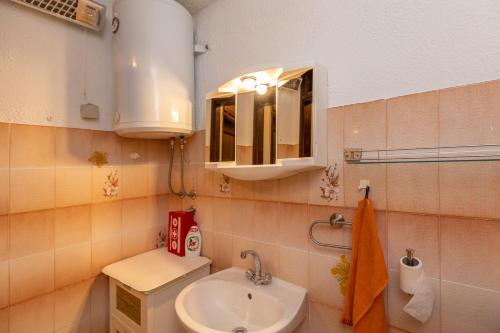 a small bathroom with a sink and a mirror at Guest House Blue Wave in Dubrovnik