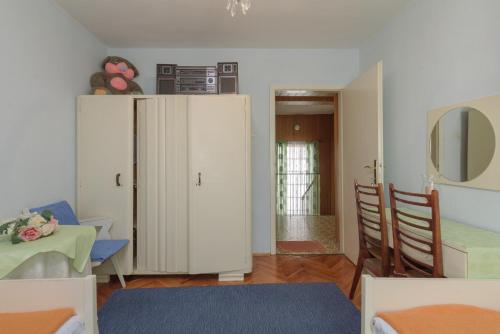 ein Wohnzimmer mit einem weißen Schrank und einem Tisch in der Unterkunft Rooms Mirjana - Centre of Trogir in Trogir