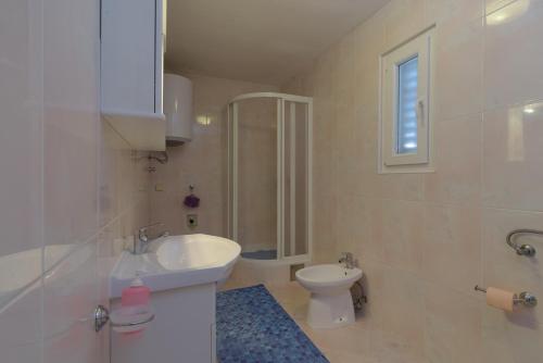 ein weißes Bad mit einem Waschbecken und einem WC in der Unterkunft Rooms Mirjana - Centre of Trogir in Trogir
