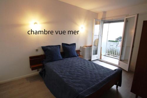 a bedroom with a bed with a sign that sayschange wemet at Appartement Vue Mer 180deg in Saint-Georges-de-Didonne