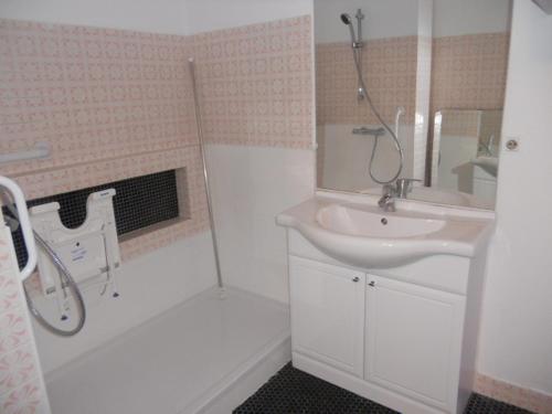 a white bathroom with a sink and a shower at Appartement Vue Mer 180deg in Saint-Georges-de-Didonne