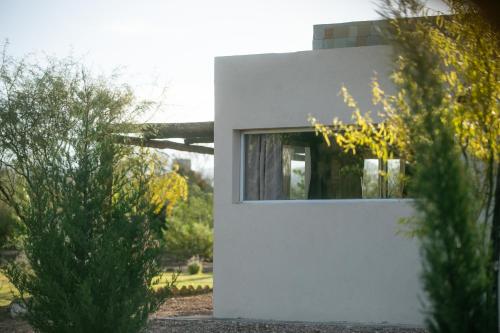 a white building with a window on the side of it at Cabañas EcoNature in Valle Grande