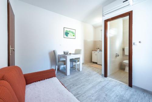 ein Wohnzimmer mit einem Tisch und ein Badezimmer in der Unterkunft Apartments Radulj in Goveđari