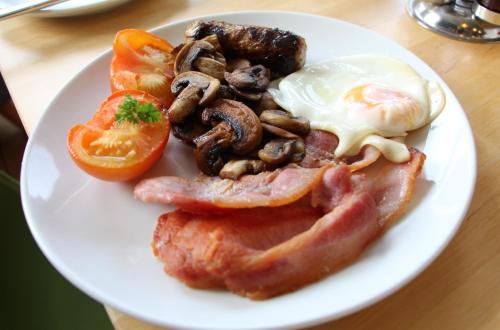a plate of food with eggs bacon mushrooms and tomatoes at Ravilious in Eastbourne