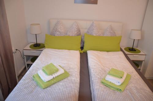 a bedroom with two beds with towels and two lamps at Pension & Restaurant La Amalia in Bad Sauerbrunn