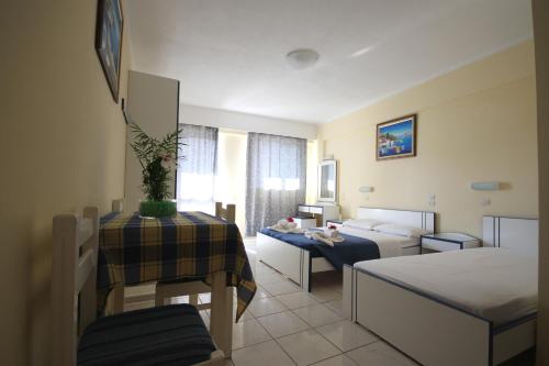 a hotel room with a bedroom with two beds and a table at Minas Apartments in Hersonissos