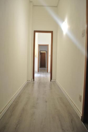 an empty room with a hallway with white walls and wood floors at Sunrise Hostel & Rooms in Palermo