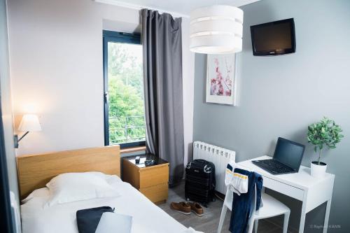 Schlafzimmer mit einem Bett und einem Schreibtisch mit einem Laptop in der Unterkunft Domaine de Garabaud in Mazères