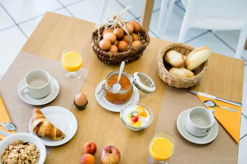une table avec des œufs et des paniers de pain et d'oranges dans l'établissement Domaine de Garabaud, à Mazères