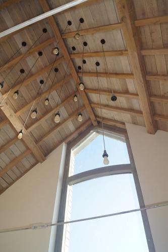 a room with a wooden ceiling with a window at 't en lande in Alveringem