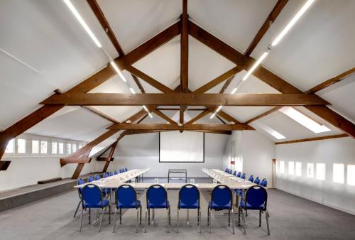 a conference room with a long table and blue chairs at Domaine et Golf de Vaugouard - La Maison Younan in Fontenay-sur-Loing