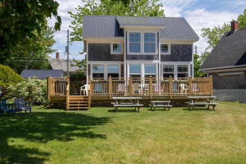 a large deck with benches in front of a house at Seaside Beach Resort in Saint Andrews
