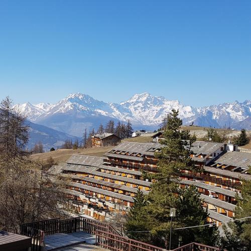 a group of buildings with snow capped mountains in the background at La casa di Pila in Pila