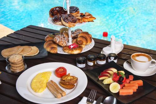 a table topped with plates of breakfast foods and coffee at DATA Resort by Della Adventure in Lonavala
