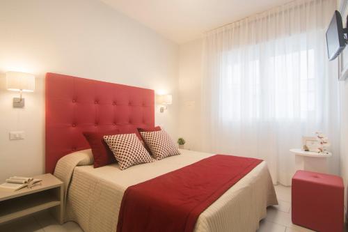 a bedroom with a large bed with a red headboard at Hotel Solemare - Frontemare - 3 Stelle Superior in Lido di Jesolo