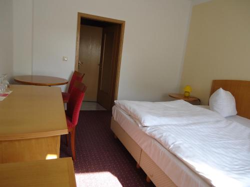 a hotel room with a bed and a table at Hotel Schweizer Hof in Halle an der Saale