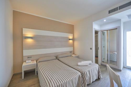 a bedroom with a bed with a striped blanket at MLL Palma Bay Club Resort in El Arenal