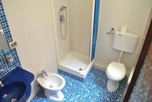 a bathroom with a shower and a toilet and a sink at Sunrise Hostel & Rooms in Palermo