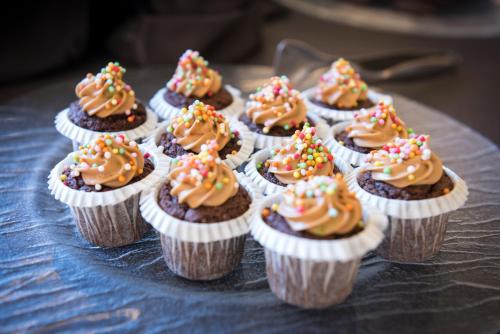 a group of cupcakes with frosting and sprinkles on a table at Pietre Nere Resort & Spa in Modica