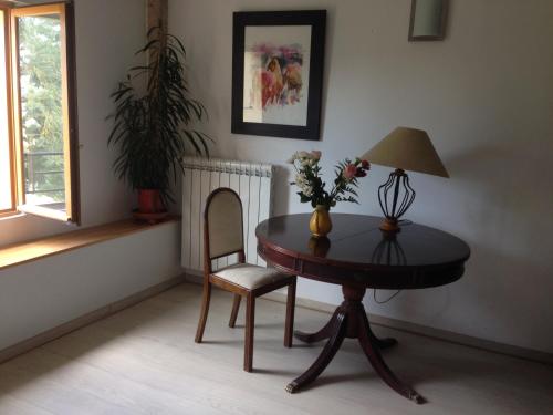 une table avec une lampe et une chaise dans une pièce dans l'établissement la maison ocre, à Saint-Julien-de-Briola