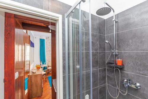 a bathroom with a shower with a glass door at The Art Republic 2, Old Town in Dubrovnik