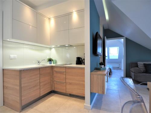 a kitchen with a sink and a living room at VIP Apartamenty Stara Polana 2 in Zakopane