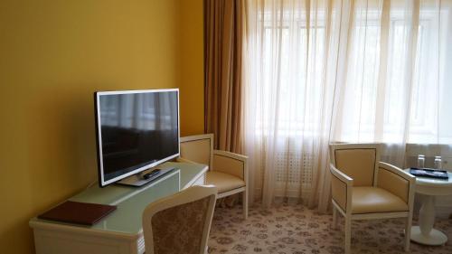a room with a television on a desk with chairs at Complex La Tunuri - Vila Economat in Sinaia