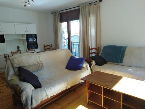 ein Wohnzimmer mit einem Sofa und einem Tisch in der Unterkunft Pis Gran i Acollidor amb LLar de Foc, a Camprodon in Camprodon