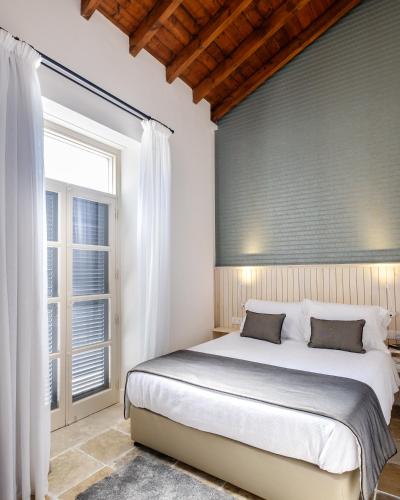 a bedroom with a large bed and a window at Limassol Old Town Mansion in Limassol