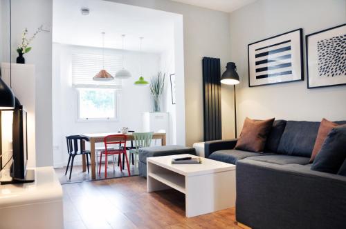 - un salon avec un canapé et une table dans l'établissement Lamington Apartments - Hammersmith, à Londres