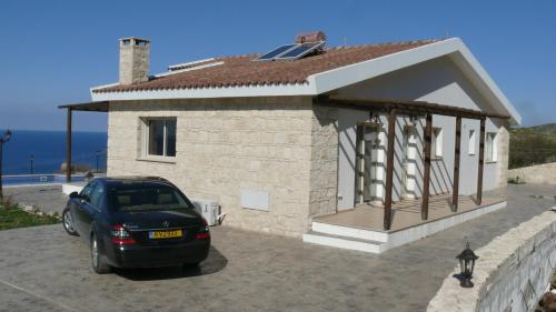 a car parked in front of a small house at Happy Trails Pomos Panoramic Villa in Pomos