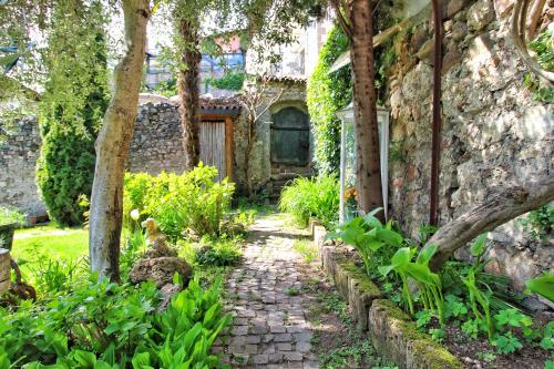 a stone walkway in front of a house with trees at Maria von Buol - Wohnen in Kaltern in Caldaro