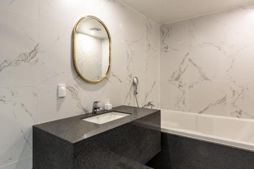 a bathroom with a sink and a mirror on the wall at Brown Dot Gijang Yeonhwari in Busan