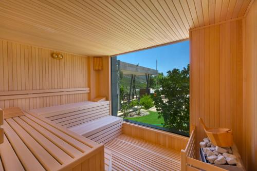 a sauna with two benches and a large window at Alya Sierra Villa Hotel in Mugla