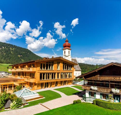 a building with a clock tower on top of it at Posthotel Achenkirch Resort and Spa - Adults Only in Achenkirch
