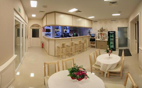 une chambre avec deux tables et une cuisine avec un comptoir dans l'établissement Belvárdi Fogadó, à Belvárdgyula