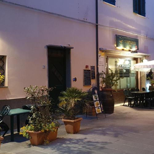 un bâtiment avec des plantes en pot devant une porte dans l'établissement Affittacamere Mazzini 78, à Grosseto