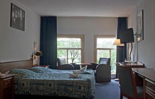 Una habitación de hotel con una cama con un animal de peluche encima. en Hotel Prins Hendrik, en Ámsterdam